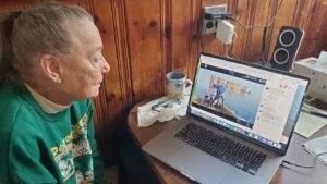 Holly Lucas looks at a computer laptop that has a photo album of her grandkid and his family