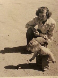 woman looking at a child who is looking at a turtle