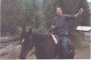 Holly Lucas waves while riding a horse near Trout Creek Montana. Photo by Mary Giovanini